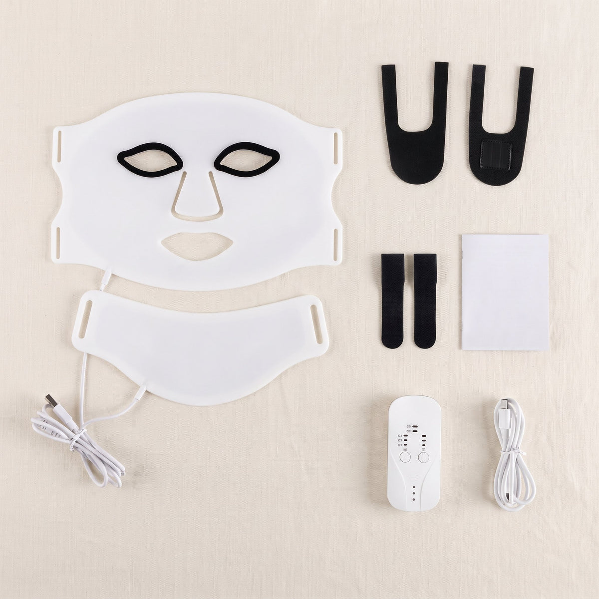 Contenu du colis : masque visage, pièce pour le cou, attaches, protège-yeux, notice, boîtier et câble, à plat