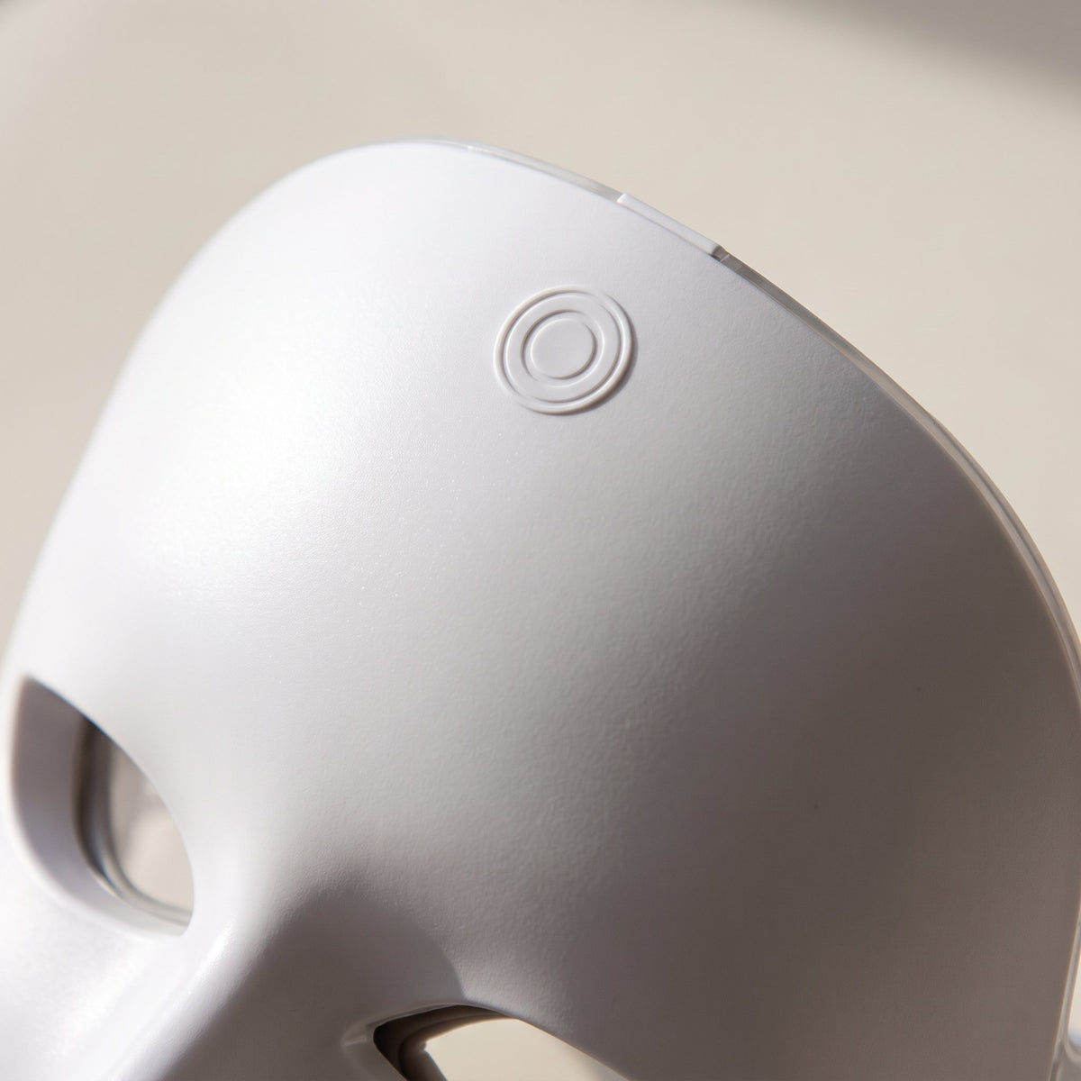 Détail en gros plan — bouton tactile du masque LED visage rigide blanc
