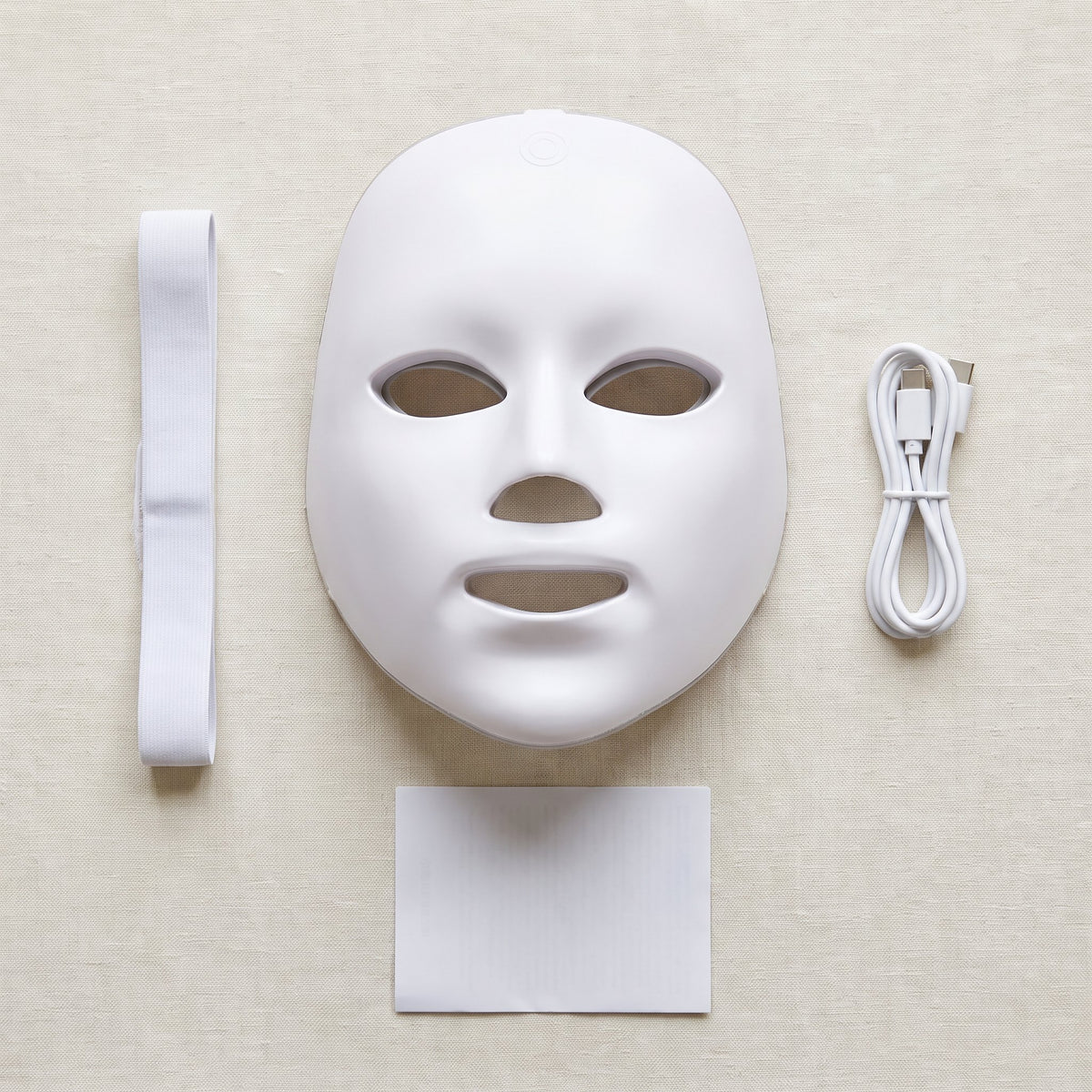 Contenu du colis : masque LED visage rigide, sangle, câble USB-C et notice, à plat