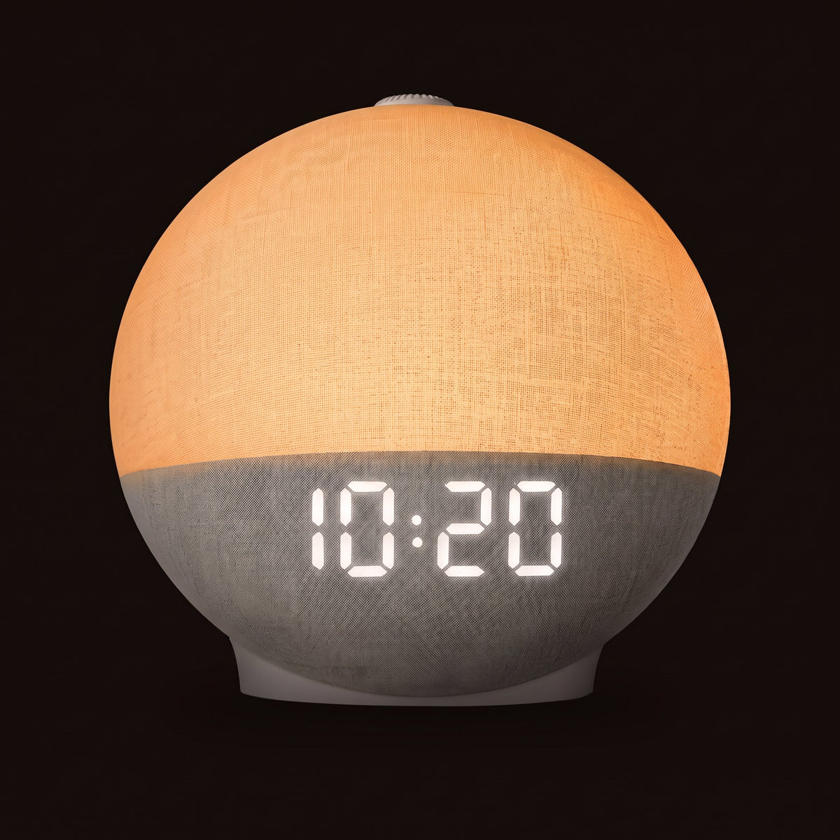 Réveil simulateur d'aube allumé, globe orangé, sur fond sombre